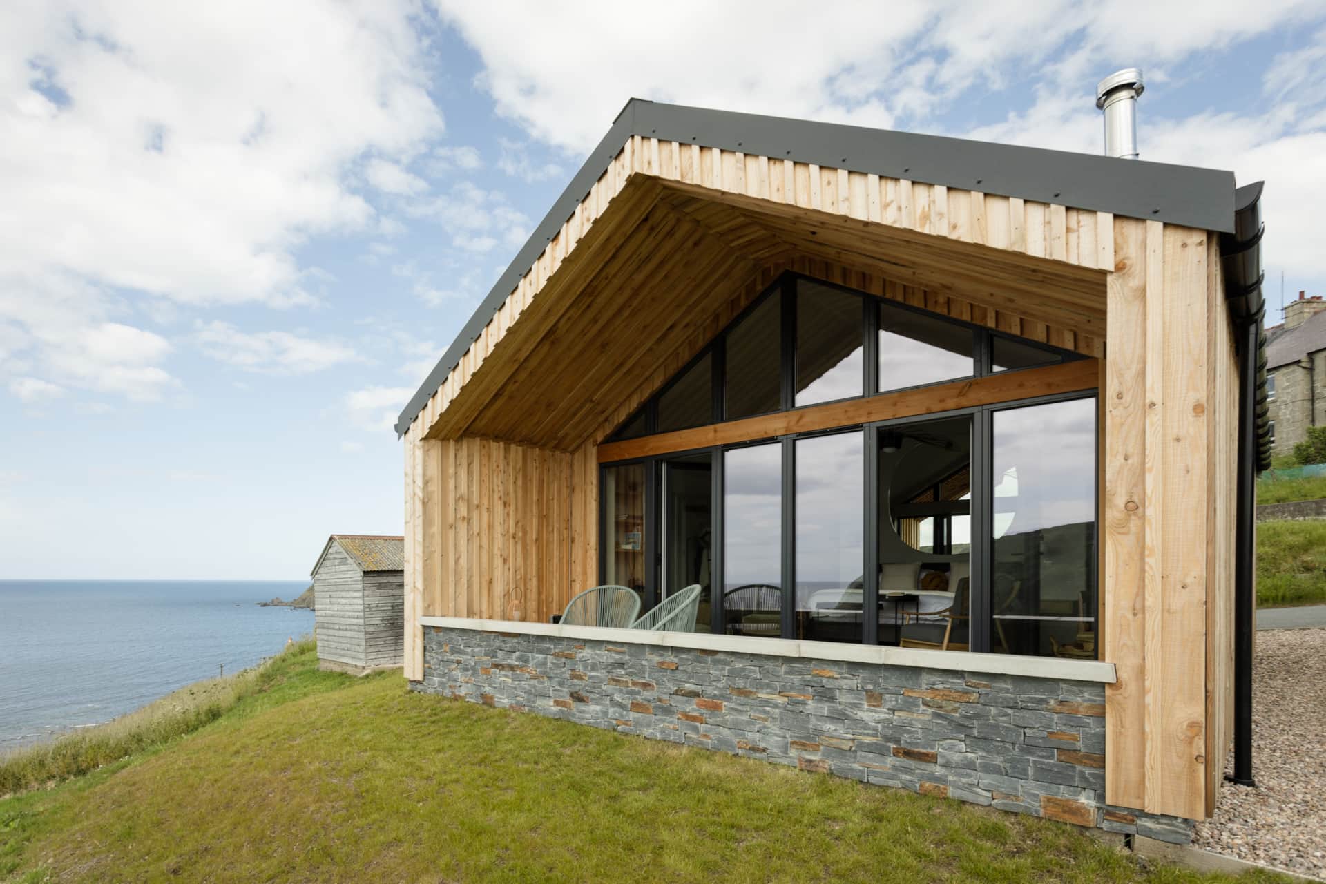Glazed gable end and terrace looking out to the Moray Firth