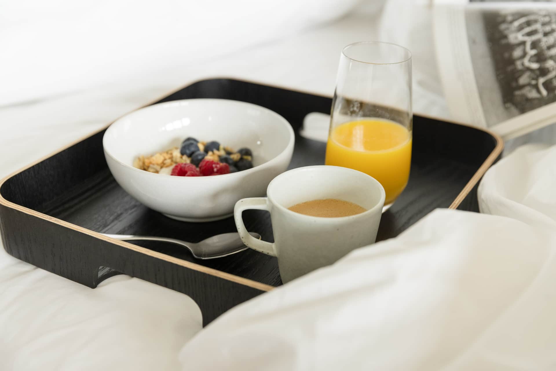 Breakfast tray with yoghurt, fruit, coffee, and orange juice