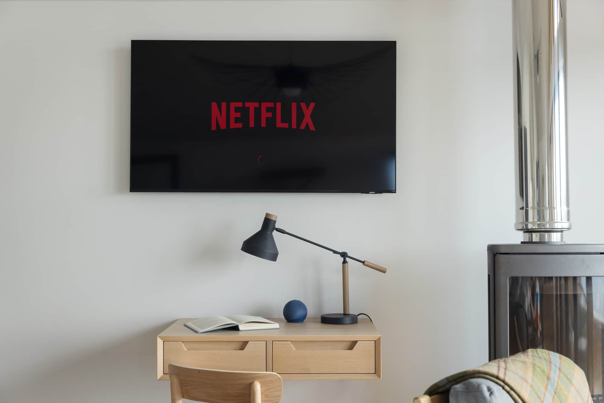 Wall-mounted TV streaming Netflix above a small desk