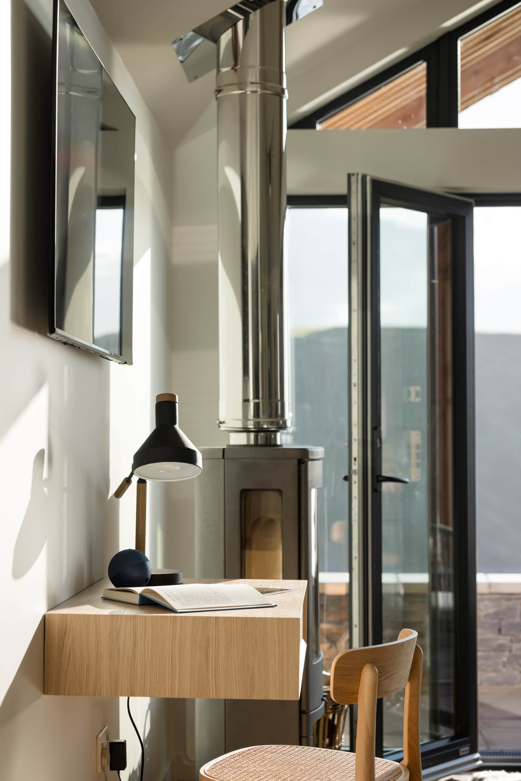 Desk nook beside the log burner flue and open bi-fold doors