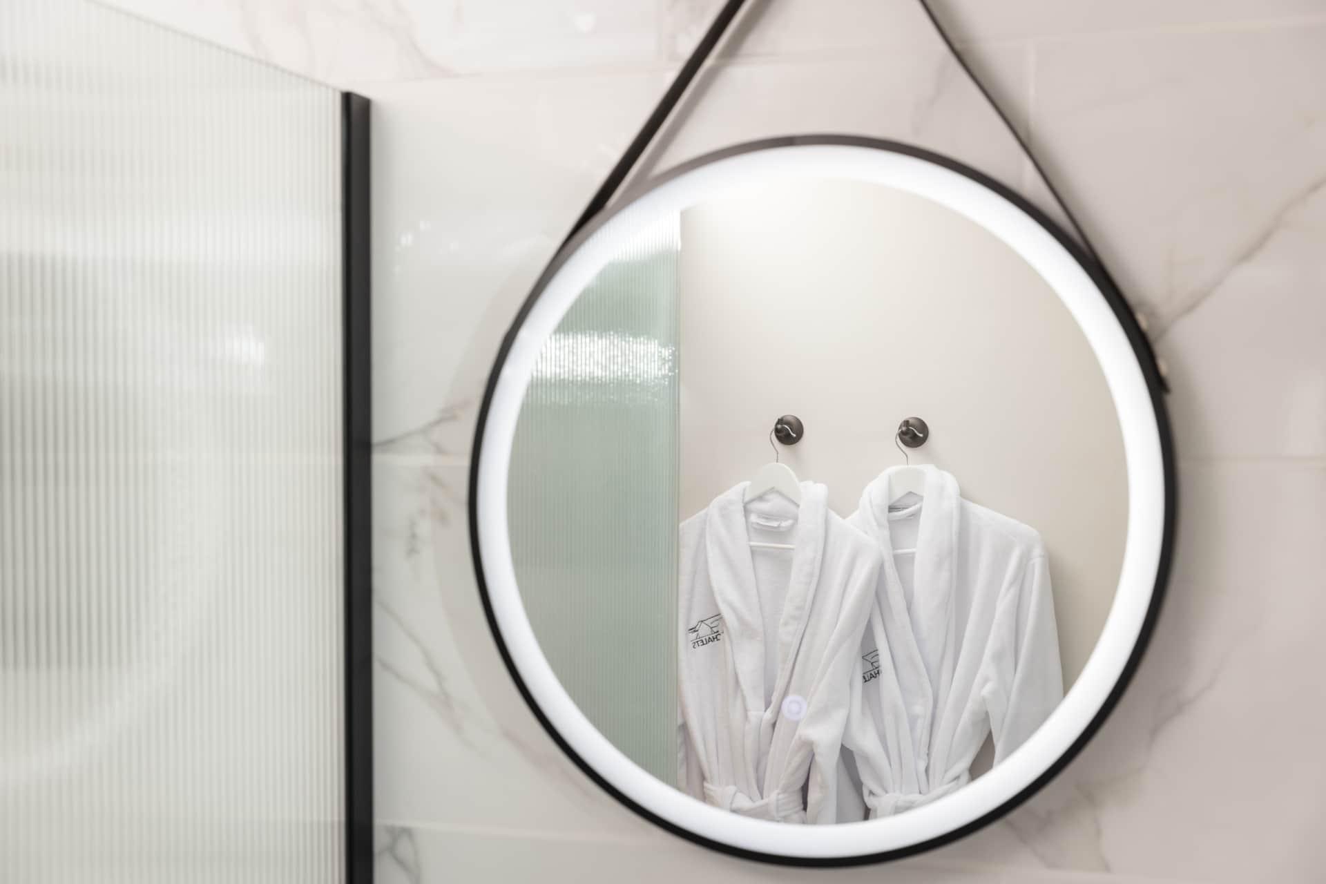 Branded bathrobes reflected in the bathroom mirror