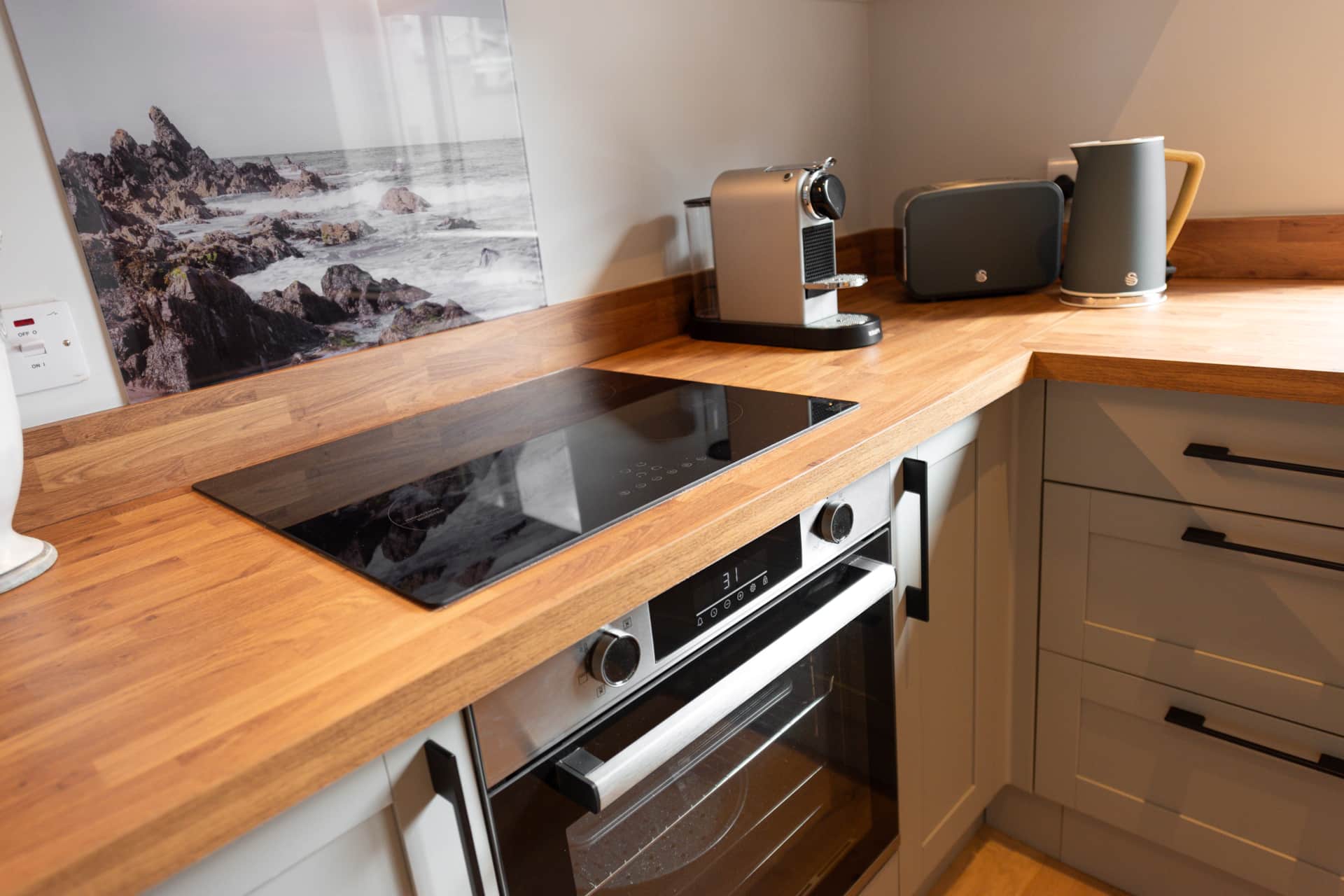 Kitchen worktop with oven, hob, and coffee machine