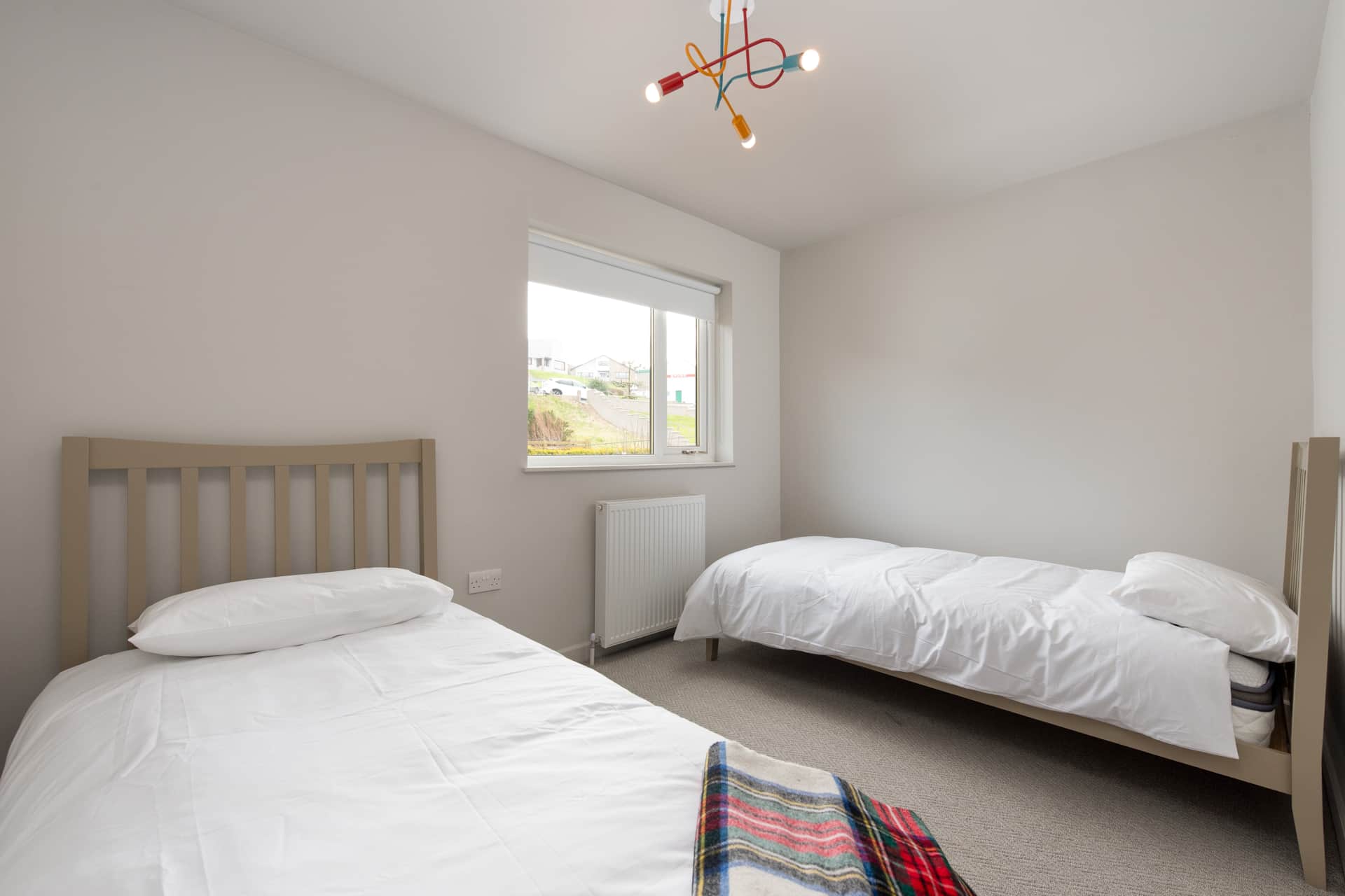 Twin beds with a tartan blanket